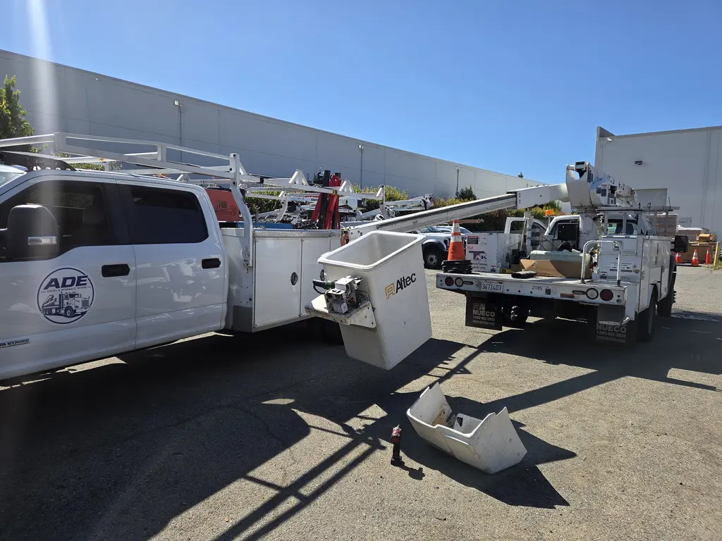 ADE Diesel and Hydraulic Repair service truck parked on site next to an Altec bucket truck
