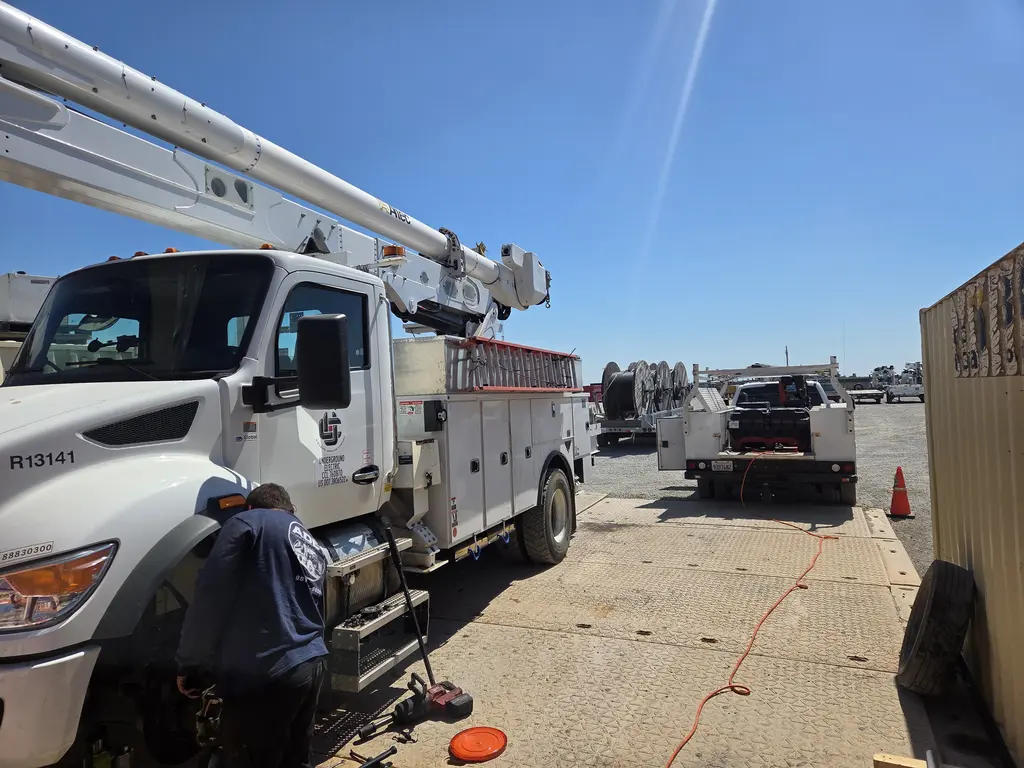 ADE technician working on an Altec bucket truck in a fleet yard