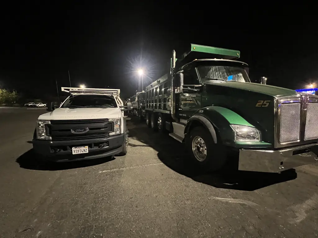 ADE service truck beside a dump truck on a night service call