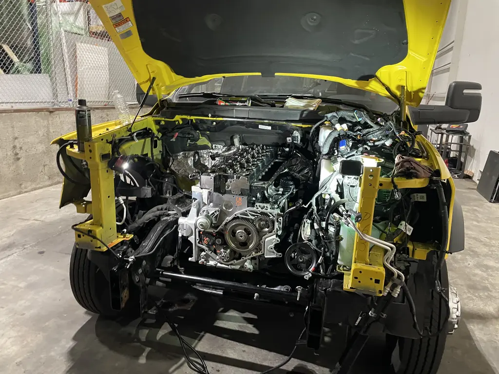 Tow truck with the front end removed and the diesel engine exposed for repair