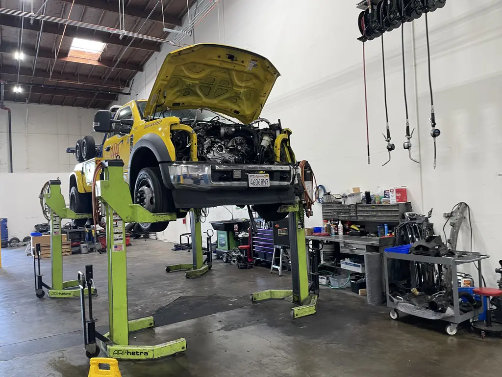 Tow trucks raised on mobile column lifts for repair